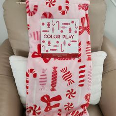 a pink and red scarf with candy canes on it, sitting in a chair