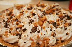 a pie topped with whipped cream and nuts