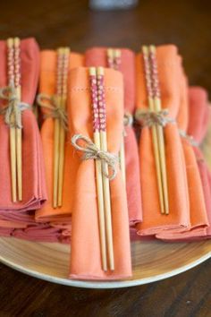 orange napkins tied with twine on a plate