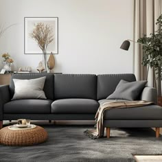 a living room with a gray couch and pillows on the floor in front of a window