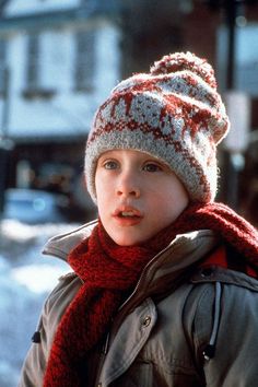 a young boy wearing a knitted hat and scarf