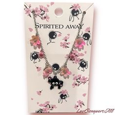 the necklace is decorated with pink flowers and black cats on it's chain,