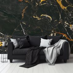 a black couch sitting in front of a marble wall