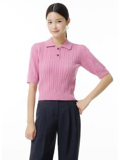 a woman in a pink sweater and black pants stands with her hands on her hips