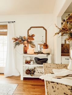 a living room filled with furniture and lots of fall decor on top of it's shelves