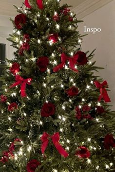 a christmas tree decorated with red roses and lights