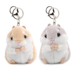 two small stuffed animals sitting next to each other on top of keychain holders