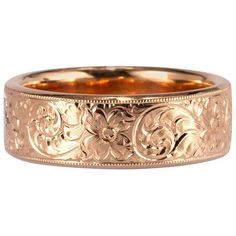 a gold wedding ring with floral designs on it