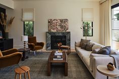 a living room filled with furniture and a fire place in the middle of the room