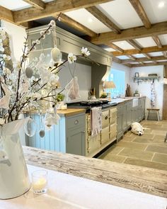 a vase filled with white flowers sitting on top of a counter next to an oven