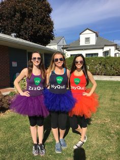 three girls in tutu skirts are standing on the grass outside their house and smiling at the camera