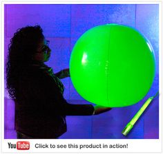 a woman holding a large green ball in her hand