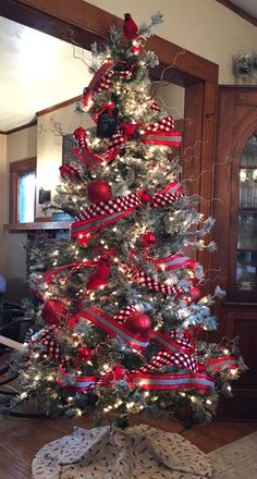 a christmas tree decorated with red and white ribbon