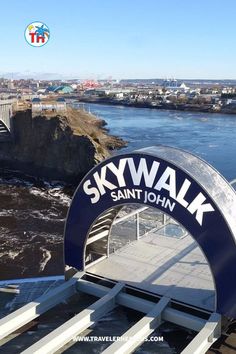 the skywalk sign is in front of the water and bridge that goes over it