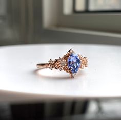 a tan and blue ring sitting on top of a white table next to a window