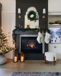 a living room decorated for christmas with stockings hanging on the fireplace mantel and wreaths