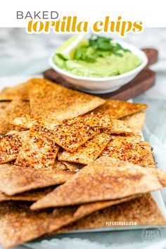 baked tortilla chips on a plate with guacamole in the background