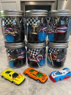 six plastic toy cars are lined up next to each other on a countertop in a kitchen