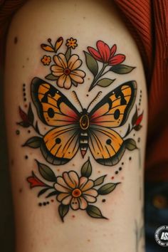 a woman's arm with an orange butterfly and flowers tattoo on the left side