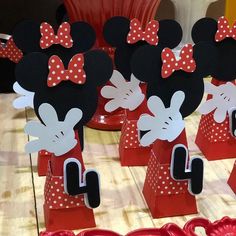 mickey and minnie mouse centerpieces on display in front of red plates with utensils