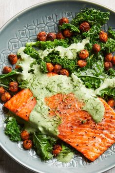 a plate with salmon, lettuce and chickpeas topped with avocado dressing