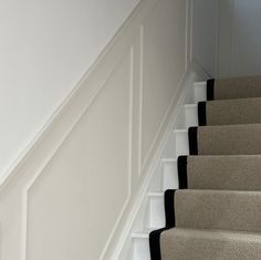 the stairs are lined with black and white carpet