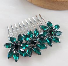 the hair combs are adorned with green crystals