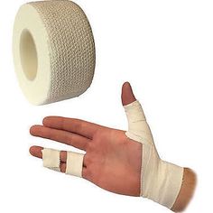 a hand with bandages on it next to a roll of toilet paper