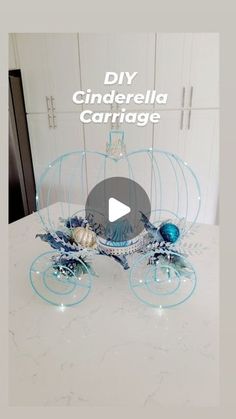 a white table topped with a glass carriage filled with blue flowers and seashells