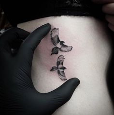 a woman's stomach with two birds on it and one bird flying in the air