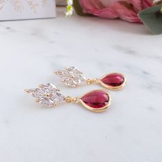 Our stunning Berry Red Drop Earrings, boast ruby red crystals delicately suspended from gold posts. Perfect for proms or bridal occasions, these rhinestone dangle earrings evoke the glamour of old Hollywood and serve as a memorable gift option for bridesmaids. DETAILS:-------------- sterling silver ear sticks- gold plated settings- glass crystalsDIMENSION:----------------Earrings : 0.5 inch x 1.5 inch long Ruby Drop Earrings For Party, Ruby Drop Earrings For Bridal Party, Elegant Ruby Bridal Earrings For Wedding, Glamorous Red Earrings For Wedding, Elegant Ruby Bridal Earrings For Party, Glamorous Red Wedding Earrings, Gold Ruby Bridal Earrings For Wedding, Formal Red Cubic Zirconia Bridal Earrings, Elegant Red Bridal Earrings For Anniversary