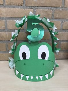 a paper crown with a green dragon head and number five on it's face