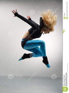 a woman in black top and blue pants jumping