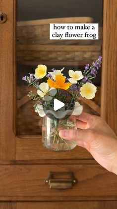 a person holding a vase with flowers in it