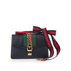 The Gucci Sylvie is regal and timeless; with shined calfskin leather and classic red, green and gold Gucci colours for a luxurious finish. Gucci have been generous in providing two straps so you can chose you style according to occasion or mood. The first is classic black leather, and the second is the more quirky red and navy ribbon that intertwines to create a charming bow -interchangeable for daytime or evening use. Look royal with The Sylvie in a fitted suit or midi dress. SPL Exterior Calfskin leather Gold toned hardware Two interchangeable straps – One in black leather, one in navy and red ribbon Red and green panel Turn lock fastening Brand new condition Interior Zip pocket Slot pockets Leather lining Immaculate, unused condition Complete with dustbag SPL Height: 17 cm Width: 27 cm Gucci Sylvie, Navy Ribbon, Fitted Suit, Small Shoulder Bag, Exclusive Bag, Red Ribbon, New Bag, Grosgrain Ribbon, Green And Gold