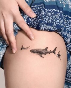 a woman's thigh with two fish on it and the bottom part of her leg