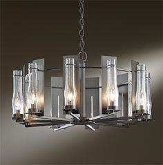 a chrome chandelier with clear glass bottles hanging from it's centerpiece