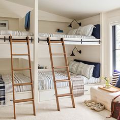 two bunk beds in a room with white walls and carpeted flooring, one has a ladder that leads to the second bed