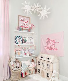 a white and pink christmas themed room with snowflakes hanging from the ceiling above