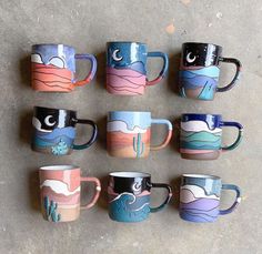 six coffee mugs are lined up on the floor with different designs painted on them