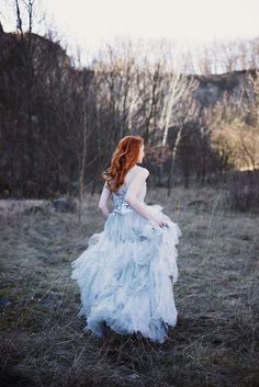 a woman with red hair wearing a blue dress