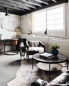 a living room filled with furniture and a table in front of a window on top of a rug