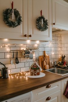 a kitchen decorated for christmas with wreaths and lights