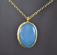 A jade stone in a striking blue makes this short necklace an eye-catcher. The stone was set in a gold plated frame made of brass. A summerly accessory. The matching earrings, bangle and ring are available in our shop: https://www.etsy.com/de/listing/1021593620/jade-ring-messing-vergoldet-verstellbar?ref=shop_home_active_3&frs=1 https://www.etsy.com/de/listing/1035548183/jade-ohrringe-vergoldet-messing-oval?ref=shop_home_active_1&frs=1 https://www.etsy.com/de/listing/1021598562/jade-armreif-vergoldet-messing-blau-oval?ref=shop_home_active_2&frs=1 Chain length: 45 cm Pendant: approx. 2.5 cm Jade: 13 mm x 18 mm ♥ Handmade with Love Every product in our shop can be customised for free. Send us a message! Gold Jewelry With Large Oval Cabochon Stone, Elegant Blue Brass Necklace, Gold Necklaces With Large Stone In Oval Pendant, Gold Necklace With Large Oval Pendant Stone, Gold Necklace With Large Oval Stone Pendant, Yellow Gold Necklace With Large Stone For Gift, Gold Necklace With Large Round Pendant, Gold Plated Oval Pendant Necklace, Blue Gemstone Necklace With Oval Cabochon