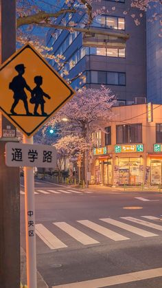 a yellow pedestrian crossing sign sitting on the side of a road