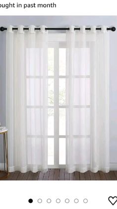 a white curtain hanging on the side of a window