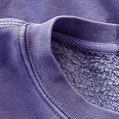 the back of a purple shirt with white stitching