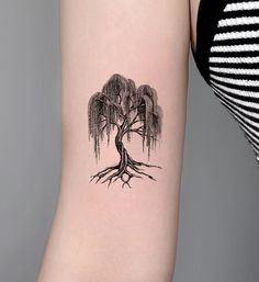 a woman's arm with a tree tattoo on the left side of her body