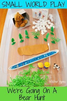 a plastic container filled with green grass and toys