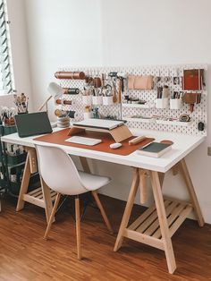 a white desk with two chairs next to it and shelves on the wall behind it